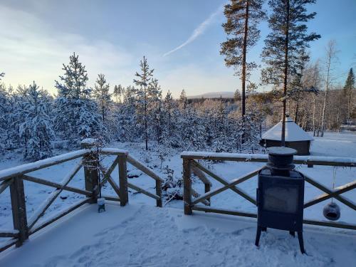 a snow covered yard with a fence and a light at Magisch berghuisje met uitzicht op Nationaal Park Fulufjället in Sörsjön
