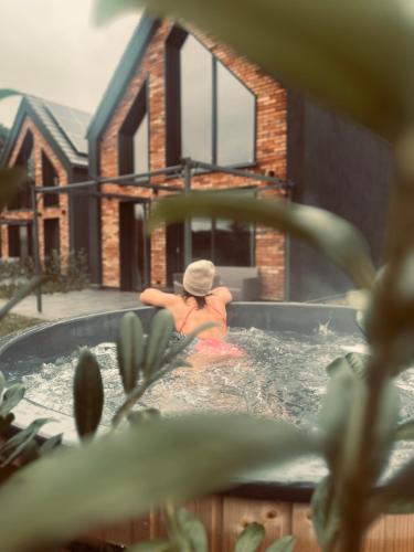a woman in a hot tub in a house at Widać Wydmy in Łeba