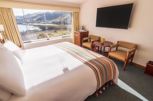 a hotel room with a large bed and a window at GHL Hotel Lago Titicaca in Puno