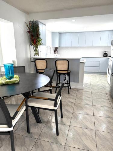 a dining room with a table and chairs and a kitchen at This is a beachfront 3 bedroom, 3 bathroom villa, family-friendly activities in Christ Church