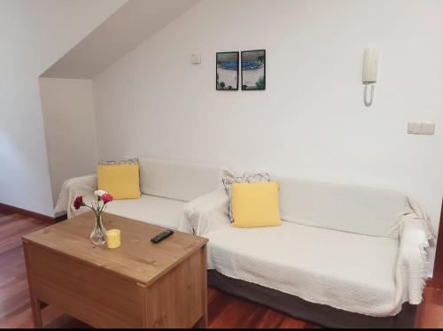 a living room with a white couch and a table at Ca Na Martina in Carreña de Cabrales 