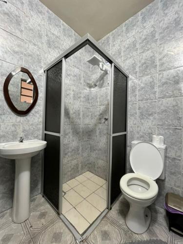 a bathroom with a shower with a toilet and a sink at Hotel Lima in Barra do Turvo