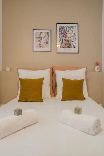 un grand lit blanc avec deux oreillers dessus dans l'établissement Confort et élégance à 2 pas du Vieux Port - ChezSo, à Marseille