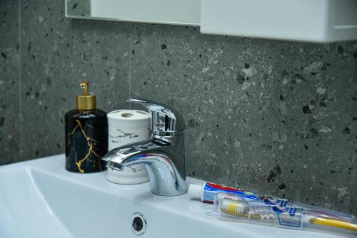 a sink with a toothbrush and a faucet on it at ЖК Бавария возле клиники Дару in Aktobe