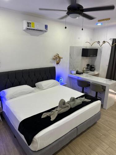 a bedroom with a bed and a desk in a room at H et L in Tortuguero