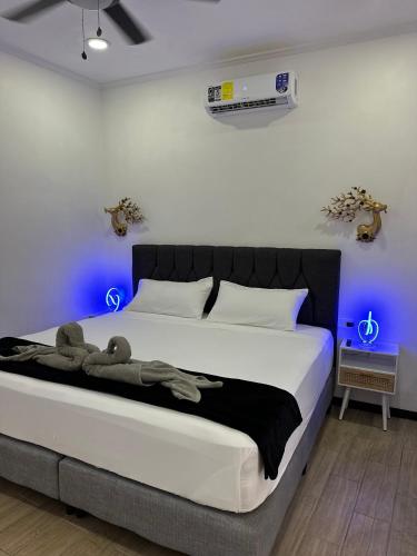 a bedroom with a large bed with blue lights at H et L in Tortuguero