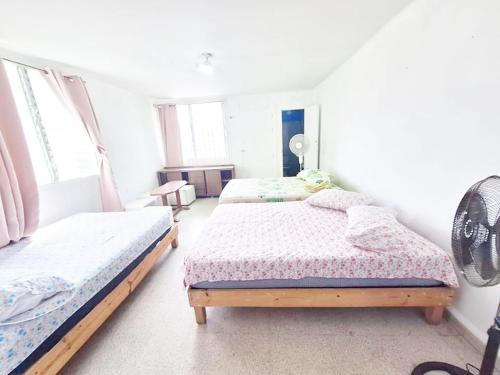 a bedroom with two beds and two windows at Recamaras Acuario Veracruz DISPONIBLE planta alta RESERVA unicamente WHATS number 228ll5476O - N0 RESERVATl0NS HERE in Veracruz