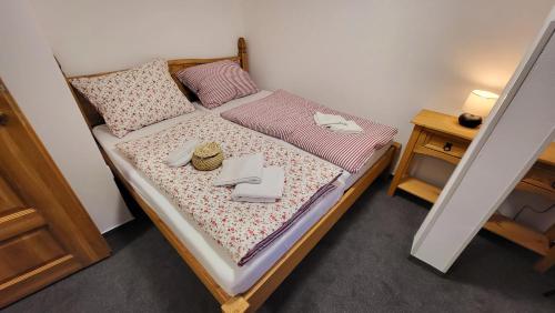 a small bedroom with a bed with pink sheets at Penzion Na Staré cestě in Deštné v Orlických horách
