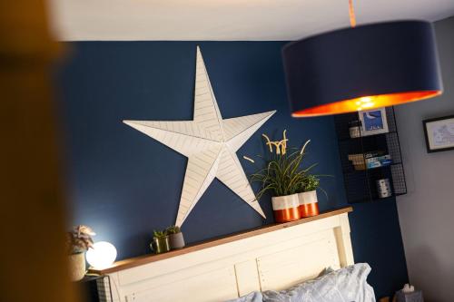a large star on a blue wall next to a lamp at Number 19 in Ripon