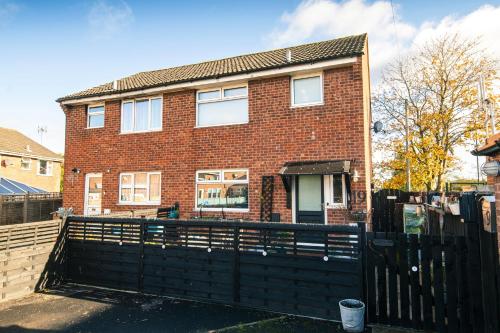 a brick house with a black fence in front of it at Number 19 in Ripon