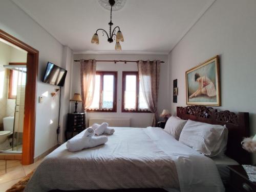 a bedroom with a bed with two towels on it at Δωμάτια με Θέα in Volos
