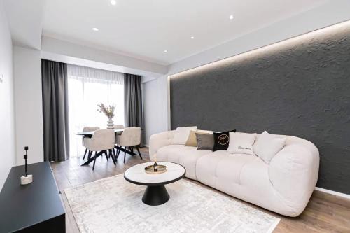 a living room with a white couch and a table at APARTAMENTS CIOCANA & TAXI AiROPORT in Chişinău
