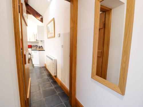 einen Flur mit einem Spiegel an der Wand in der Unterkunft Cornel Glyd in Dyffryn