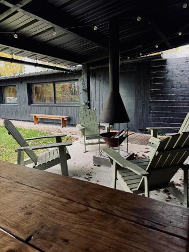 d'une terrasse avec des chaises, une table et une cheminée. dans l'établissement Le refuge du lac, à Féchain