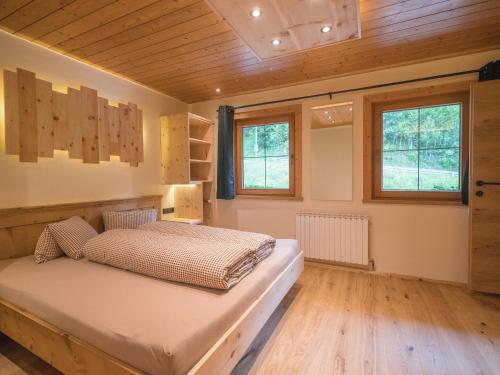 a bedroom with a bed in a room with wooden ceilings at Pension Sonderbichlhof in Pankrazberg