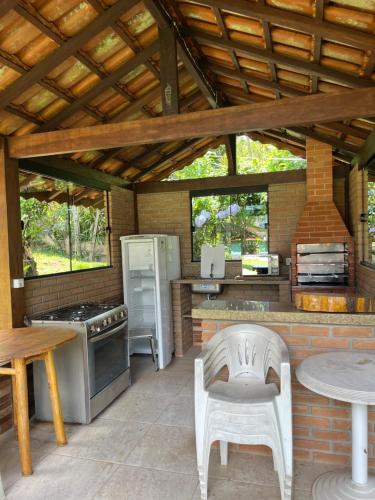 an outdoor kitchen with a stove and a refrigerator at Pousada Brilho da Natureza in Visconde De Maua