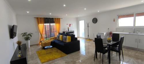 uma sala de estar com um sofá e uma mesa em O Infinito em Calhetas