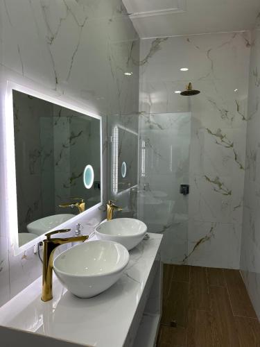 a bathroom with two sinks and a large mirror at H et L in Tortuguero