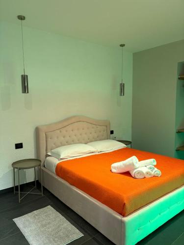 a bedroom with a bed with an orange blanket at Dimora del Centro in Rivarolo Canavese