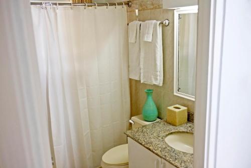 a bathroom with a white shower curtain and a sink at ZenBreak Silver Sands Villa 2 in Christ Church