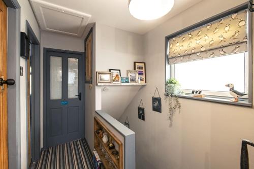 a hallway with a blue door and a window at Number 19 in Ripon