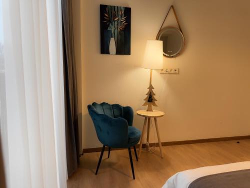 a room with a blue chair and a lamp at HOTEL ARCHI KOKHTA BAKURIANI in Bakuriani
