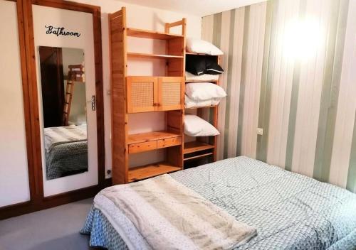 - une chambre avec un lit et un placard avec un miroir dans l'établissement Résidence La Meije - Studio cabine 4/5 pers - LE MEIJE- PLAGNE CENTRE MAE-3044, à Aime La Plagne