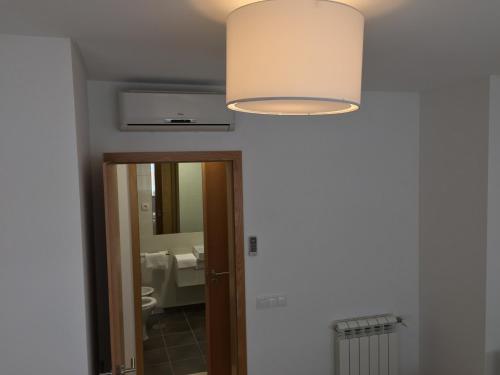 a light hanging over a bathroom with a mirror at Galante Beach Apartment in Figueira da Foz