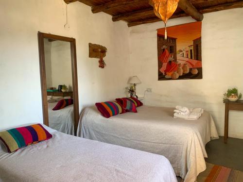a bedroom with two beds and a mirror at Casapueblo in Cachí