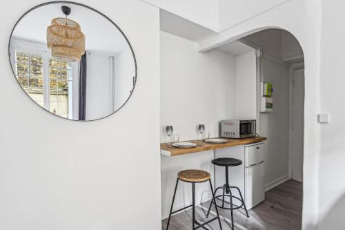 un miroir dans une cuisine avec un comptoir et des tabourets dans l'établissement Charmant studio Beaugrenelle, à Paris