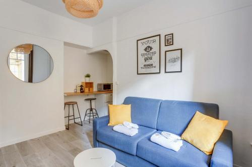 un salon avec un canapé bleu et une table dans l'établissement Charmant studio Beaugrenelle, à Paris