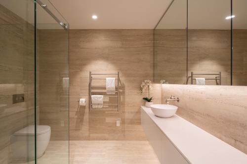 a bathroom with a toilet and a sink and a shower at The Hill Residence by Sotheby's Luxury Rental Homes in Queenstown