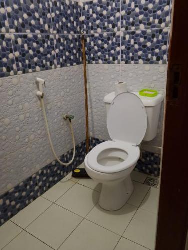 a bathroom with a toilet in a blue and white wall at La-mia-casa in Mombasa