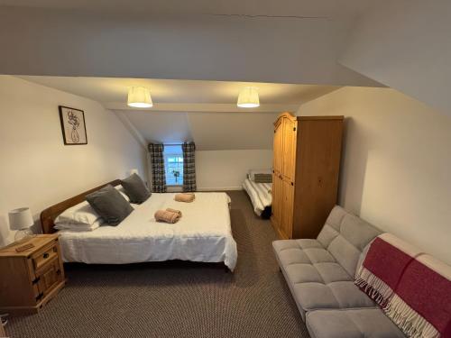 une chambre avec un lit et un canapé dans l'établissement Weaver's Cottage, à Porthmadog