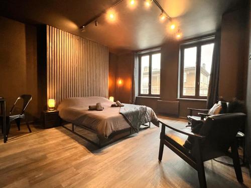 une chambre avec un lit dans une pièce avec des fenêtres dans l'établissement BLK Room Cinema, à Boulogne-sur-Mer