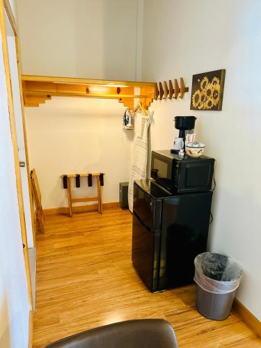 a room with a microwave on top of a refrigerator at Adobe Rose Boutique Inn in Artesia