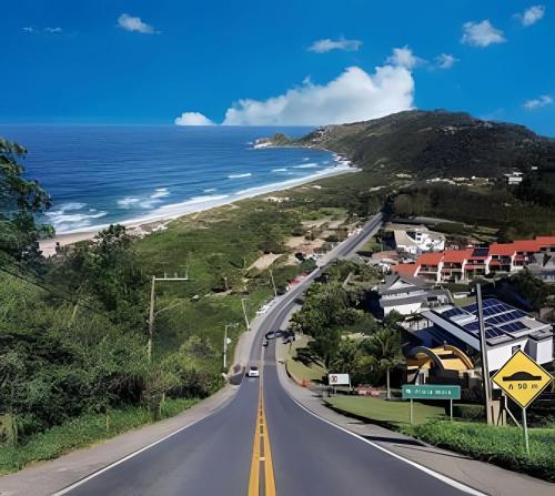 an empty road in front of a beach at Casa Perto das melhores praias Florianópolis, 8 pessoas, ar condicionado, tv, wifi, cozinha completa, lavanderia, in Florianópolis