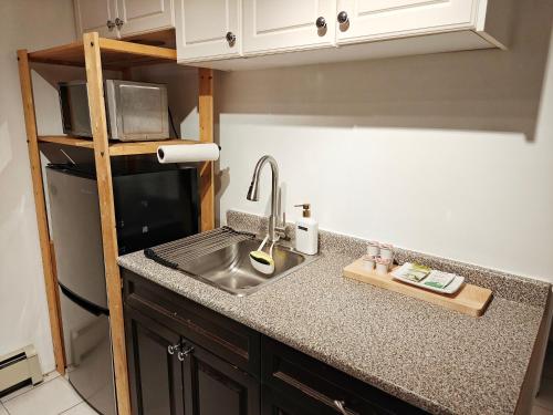 a kitchen counter with a sink and a microwave at Cozy Commercial Oasis - Private Entrance Studio in Vancouver