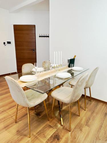 une salle à manger avec une table et des chaises en verre dans l'établissement Champagne Haven Elegant Stay in City Center, à Épernay