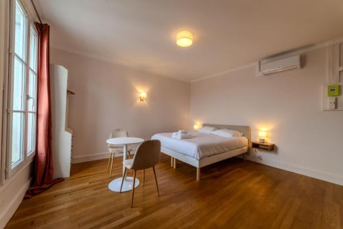 une chambre avec un lit et une table dedans dans l'établissement The charming Republic Place, à Paris