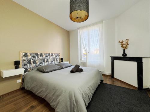 a bedroom with a bed with a headboard and a fireplace at Champagne Haven Elegant Stay in City Center in Épernay