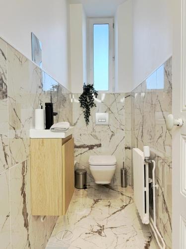 une salle de bain avec un lavabo et des toilettes dans l'établissement Champagne Haven Elegant Stay in City Center, à Épernay