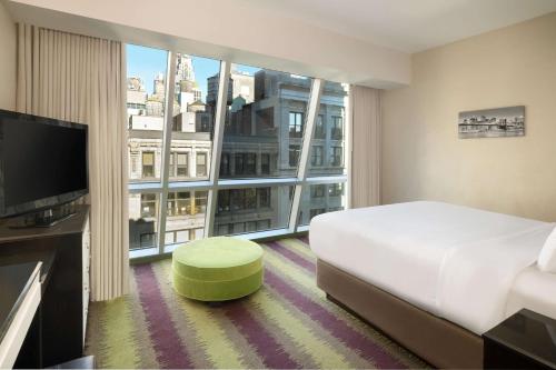 a hotel room with a bed and a large window at Best Western Premier Herald Square in New York