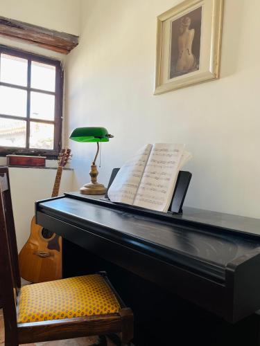 a piano with a book on top of it at Remparts House in Mailhac