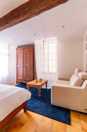 a bedroom with a bed and a couch and a table at Remparts House in Mailhac
