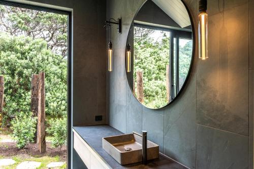 a bathroom with a sink and a mirror at Mawhiti - Stay Waiheke in Waiheke Island