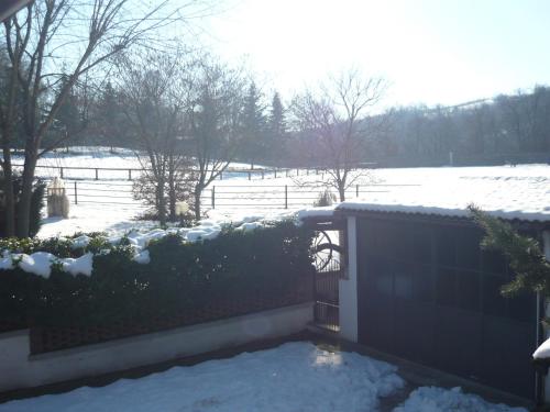 a fence with snow on it and a snowy field at Villa Paradiso in Isola d'Asti