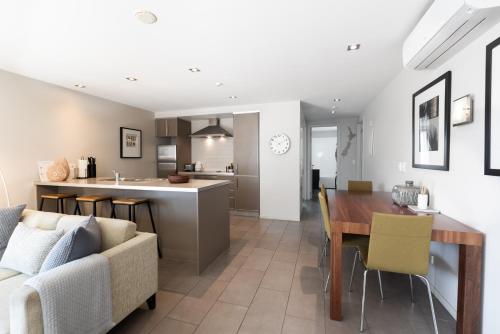 a living room and kitchen with a couch and a table at Paihia 2 Bedroom Apartment with Pool in Paihia