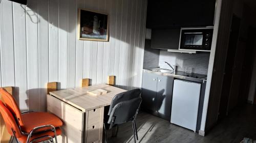 une petite cuisine avec une table et des chaises en bois dans l'établissement Résidence Soleil D'huez - APPARTEMENT ALPE D'HUEZ QUARTIER DE L'ECLOSE EST MAE-3331, à Huez