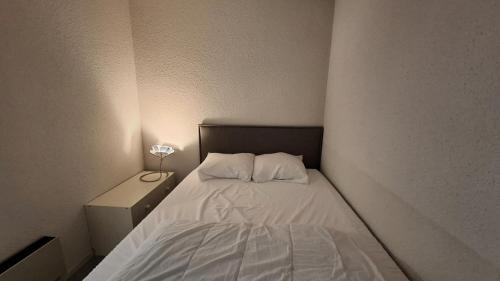 une petite chambre avec un lit avec deux oreillers dans l'établissement Résidence Skival - APPARTEMENT 2 PIECES ALPE D'HUEZ QUARTIER DE L'ECLOSE MAE-3421, à Huez